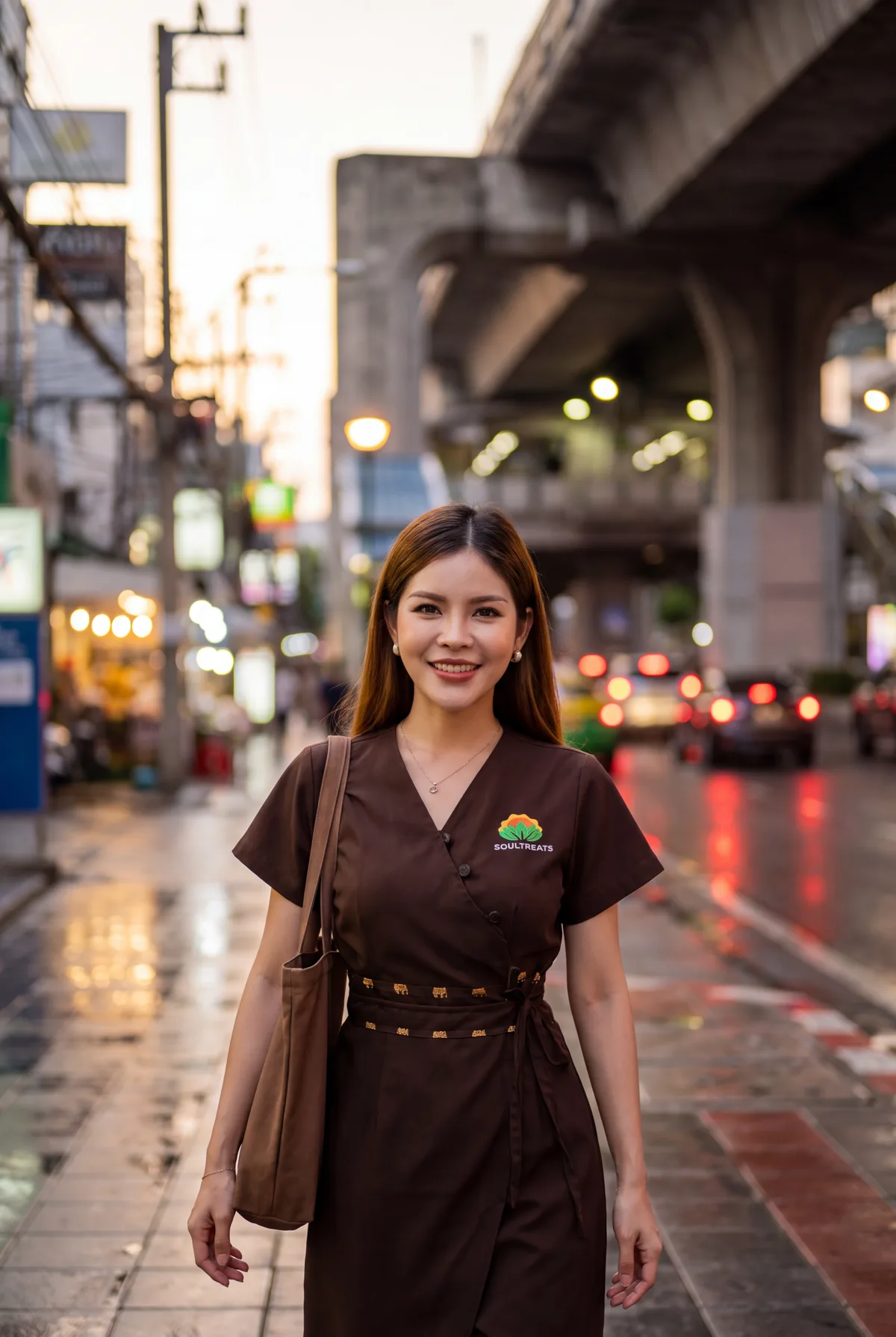 Therapist Lina walking along Sukhumvit Road under the BTS Skytrain with her bag